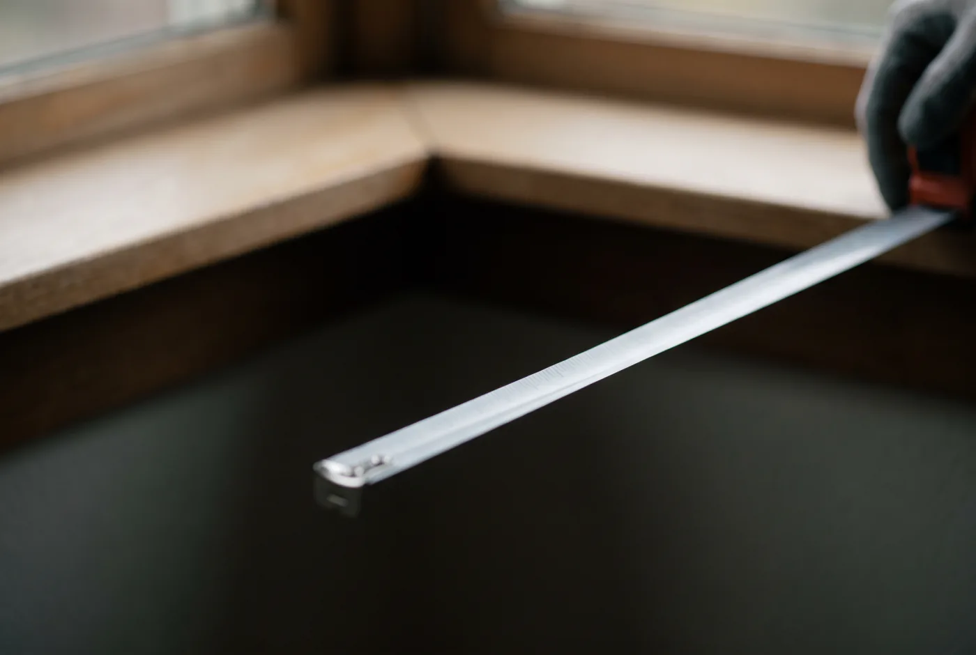 A tape measure held across the inside of a window recess
